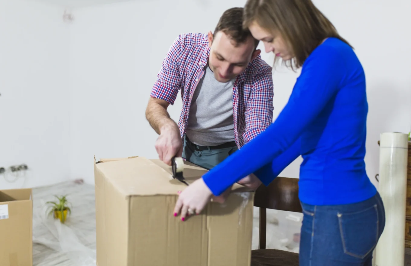 Casal aprendendo a como montar uma caixa de papelão