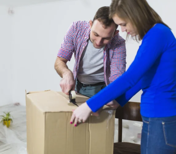 Casal aprendendo a como montar uma caixa de papelão